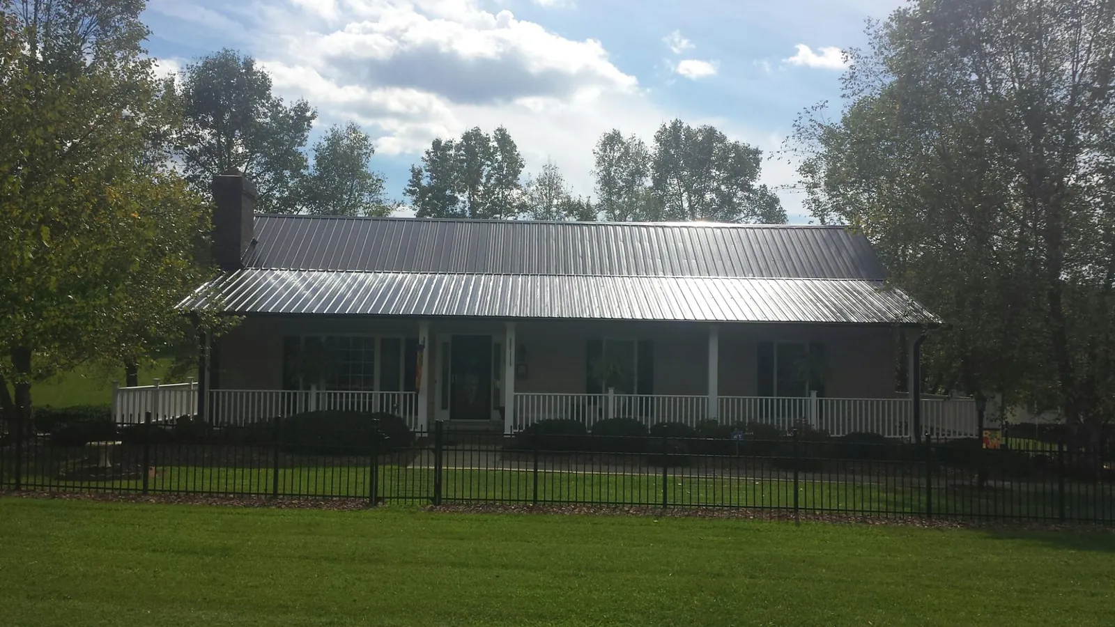 Gray metal roof on a brick ranch with a full width front porch — Gutter Guard Installation work by our crew in Simi Valley